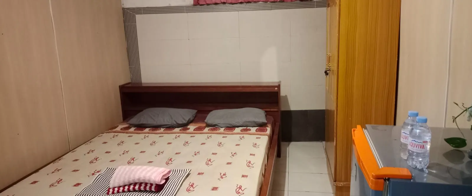 Tempat tidur double dengan kulkas pribadi di sisi kamar
