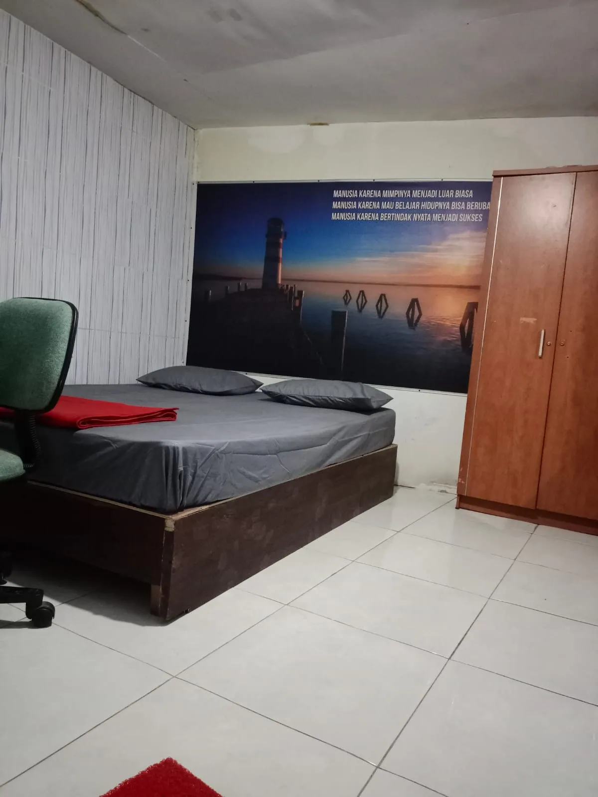 Kamar ber-AC dengan tempat tidur double dan lemari pakaian di Sampurna Homestay Surabaya